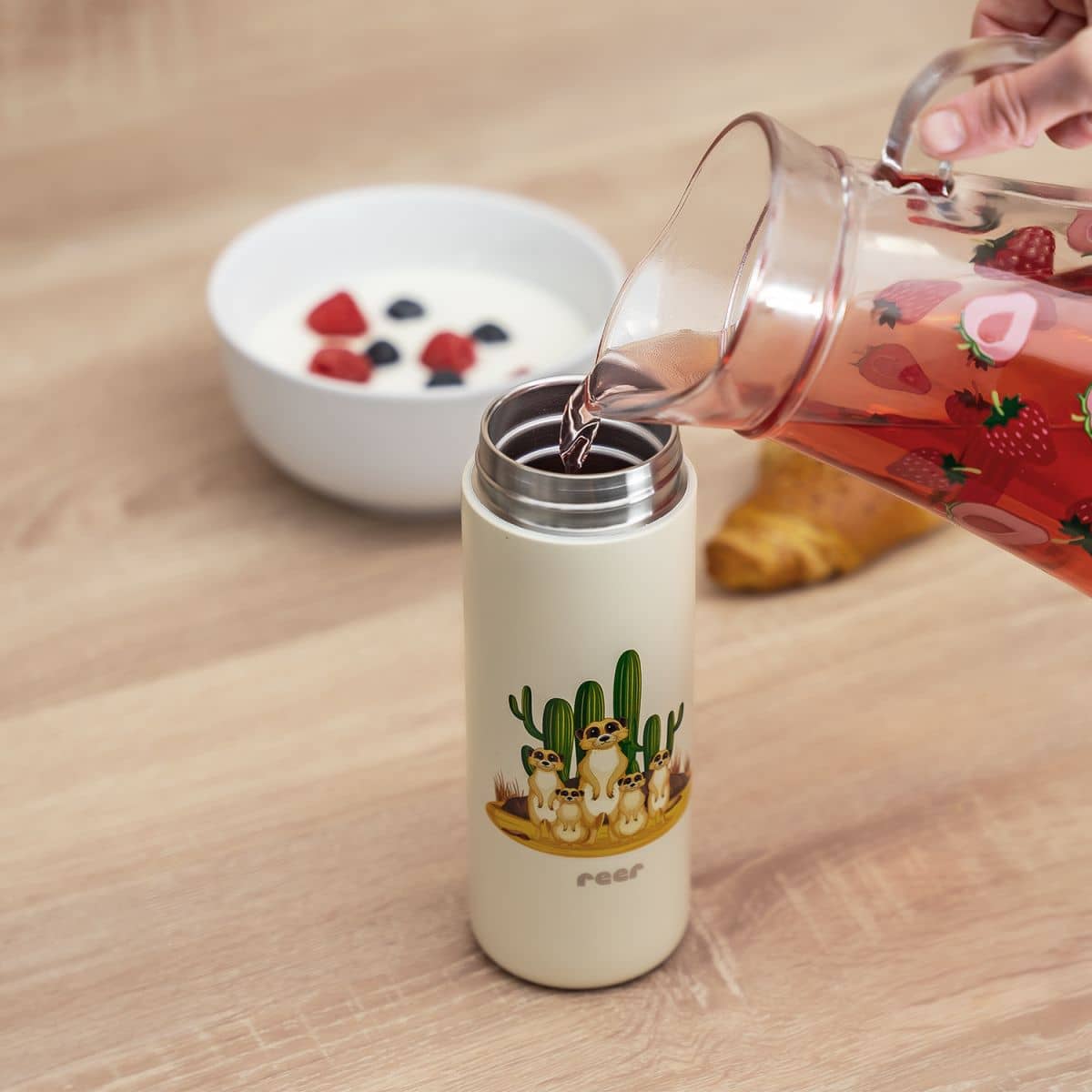 aufgeschraubte trinkhalmflasche wird mit tee gefüllt