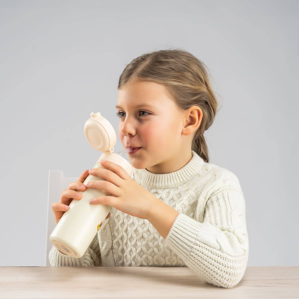 kind trinkt aus trinkhalmflasche