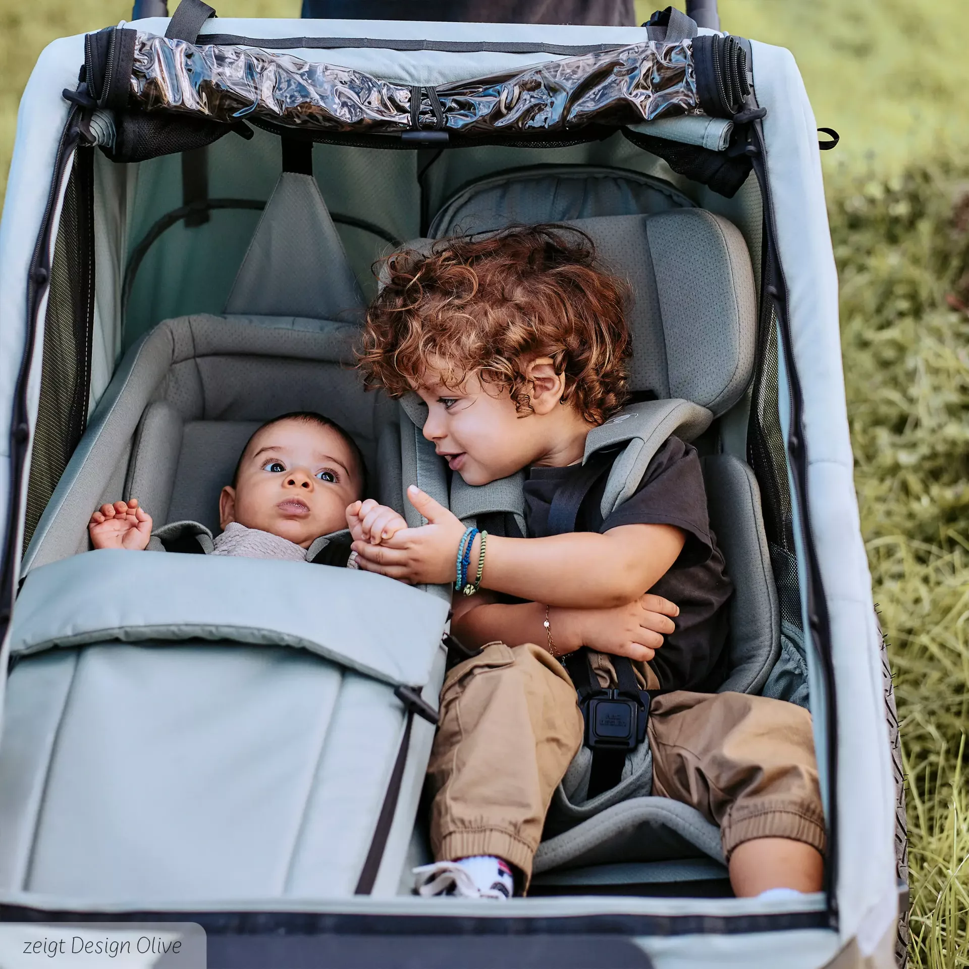 anssicht von einem kleinkind und baby wie sie im anhänger sitzen ansicht von einem kleinkind und baby wie sie im anhänger sitzen